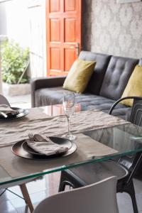 szklany stół z talerzami i kieliszek wina w obiekcie Evans Village - Stunning Apartments w mieście Johannesburg