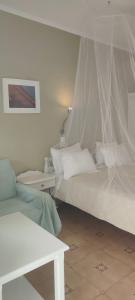 1 dormitorio con 2 camas y mosquitera en Krinelos Rooms, en Skala Eresou