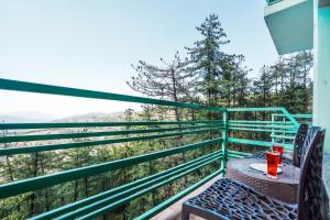 un tavolo e sedie su un balcone con vista di Green Valley Resort Mashobra By AN Hotels a Shimla