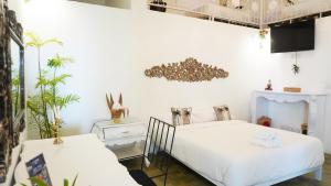 2 łóżka w pokoju z białymi ścianami w obiekcie Surga Tropical Suites w mieście Jimbaran