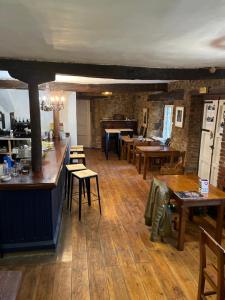 un restaurante con suelo y mesas de madera y un bar en Posada -Meson la gándara 
