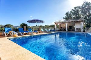 a swimming pool with chairs and an umbrella at Finca Es Recer - ETV/1.751 in Santanyi