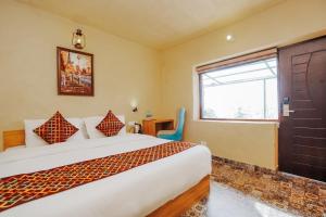 a bedroom with a large bed and a window at Nature Valley View Resort Mashobra !! Luxury Choice !! gaming zone !! open terrace !! Big Parking in Shimla +33 photos