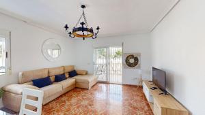 ein Wohnzimmer mit einem Sofa und einem TV in der Unterkunft Villa Greenland-A Murcia Holiday Rentals Property in Los Alcázares