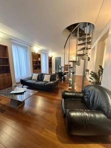 a living room with two leather couches and a staircase at Magnifique appartement Paris proche Arc Triomphe in Paris