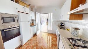 eine weiße Küche mit einer Spüle und einem Herd in der Unterkunft Villa Greenland-A Murcia Holiday Rentals Property in Los Alcázares