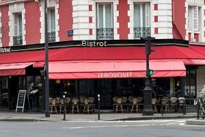 a restaurant with a red awning on a city street at Magnifique appartement Paris proche Arc Triomphe in Paris