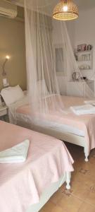 a bedroom with two beds with mosquito nets at Krinelos Rooms in Skala Eresou
