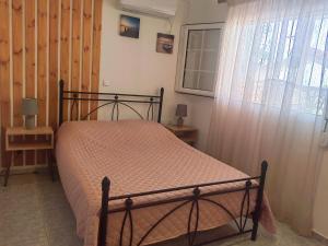 1 dormitorio con cama y ventana en ILIAKTI RELAXING SEASIDE, en Salamina