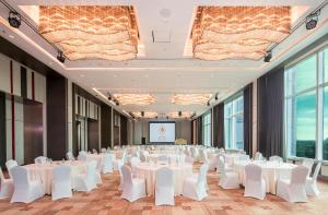 a conference room with white tables and white chairs at Eastin Grand Hotel Sathorn in Bangkok