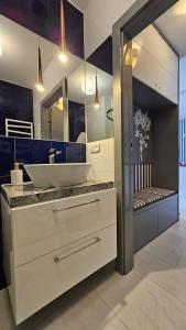a bathroom with a sink and a large mirror at Apartamenty Klifowa in Rewal