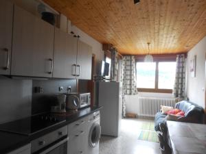 een keuken met een koelkast en een woonkamer bij bouton d or in La Bresse