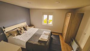 a bedroom with a large bed and a window at Casa Fonte Fria in Pitões das Júnias