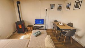 a living room with a couch and a table and a television at Casa Fonte Fria in Pitões das Júnias