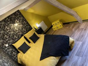 a bedroom with a large bed with yellow sheets and pillows at Gîte cosy La Joconde in Isbergues