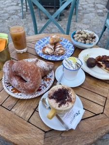 una mesa de madera cubierta con platos de repostería y bebidas en Mareluna Bed and Breakfast en Marina di Camerota