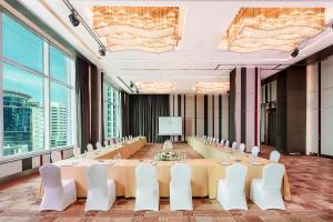 a large conference room with a long table and white chairs at Eastin Grand Hotel Sathorn in Bangkok