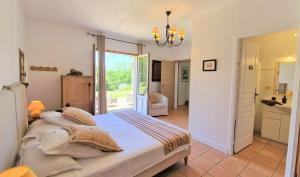 a bedroom with a large bed and a bathroom at Le Clos-Lascazes maison d'Hôtes in Le Buisson de Cadouin