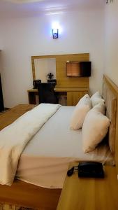 a bedroom with a large bed with pillows and a desk at JACKSON'S COURT AND APARTMENT in Rubuchi