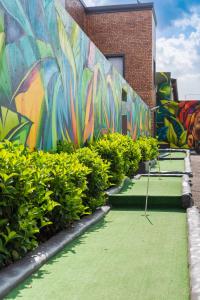 ściana z malowidłem z zieloną trawą i krzakami w obiekcie Evans Village - Stunning Apartments w mieście Johannesburg