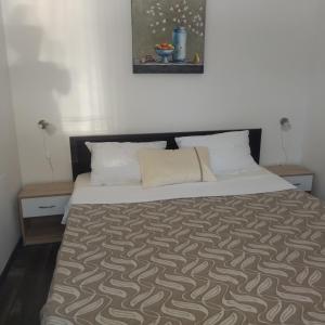 a bedroom with a bed with a brown and white comforter at Apartment Tuja in Jadrtovac