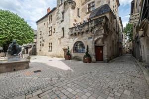 an old stone building with a statue in front of it at Wisdom at heart in Périgueux