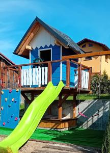 einen Spielplatz mit Rutsche und ein Haus in der Unterkunft Staro Chałpa in Istebna