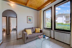 un soggiorno con divano e finestre di Al Peverì - Family Friendly - Happy Rentals a Toscolano Maderno