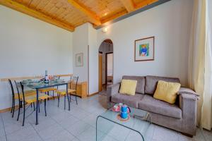 un soggiorno con divano e tavolo di Al Peverì - Family Friendly - Happy Rentals a Toscolano Maderno