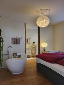 een slaapkamer met een bad naast een bed bij Wohnen am Dom in Geisenheim