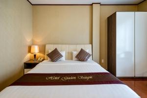 La Palma - Garden Saigon Hotel Phu My Hung في مدينة هوشي منه: غرفة نوم بسرير كبير مع مفرش أبيض