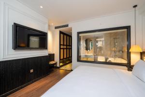 a bedroom with a large bed and a television at Luxe Paradise Premium Hotel in Hanoi