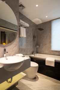 a bathroom with a sink and a toilet and a tub at Luxe Paradise Premium Hotel in Hanoi