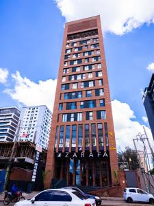 a tall building with cars parked in front of it at Zarafa Suites in Nairobi