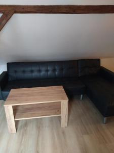 a black couch and a coffee table in a room at Penzion Hrnčíře in Benešov