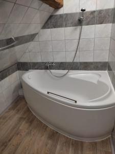 a white bath tub in a bathroom with tiles at Penzion Hrnčíře in Benešov