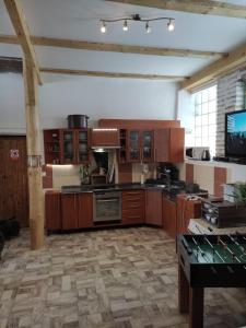 a large kitchen with wooden cabinets and a television at Penzion Hrnčíře in Benešov