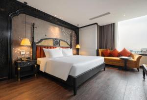 a bedroom with a large bed and a couch at Luxe Paradise Premium Hotel in Hanoi