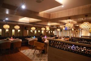 ein Restaurant mit Leuten, die an Tischen in einem Zimmer sitzen in der Unterkunft HOTEL RAMTA CONTINENTAL in Patna