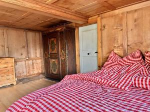 Revier Natur pur في غلروس: سرير مع بطانية حمراء وبيضاء مضمومة في الغرفة