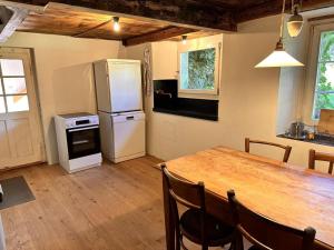 uma cozinha com uma mesa de madeira e um frigorífico em Revier Natur pur em Glarus