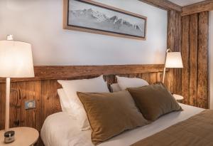 une chambre avec un lit avec une tête de lit en bois dans l'établissement Chalet Papillon - LES CHALETS COVAREL, à Val dʼIsère