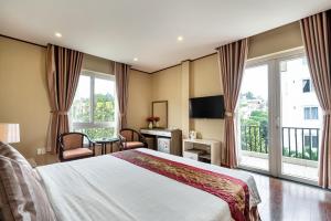 La Palma - Garden Saigon Hotel Phu My Hung في مدينة هوشي منه: غرفه فندقيه بسرير وشرفه