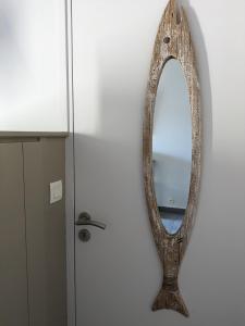 a mirror hanging on a wall next to a cabinet at L'Ile sous le Vent in Sainte-Marie-de-Ré