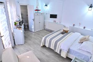 a white bedroom with a bed and a tv at Casa Fotografului Studio Marines in Constanţa