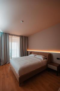 een slaapkamer met een groot bed met verlichting bij ROYAL G DELUXE in Durrës