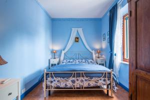 ein blaues Schlafzimmer mit einem Himmelbett in der Unterkunft Appartamento Blu in Asciano