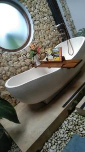 a bathroom with a white sink and a mirror at casa idea ubud in Ubud