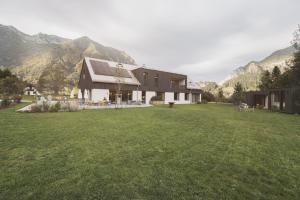 a house in a field with mountains in the background at The Campus Alps in Hieflau