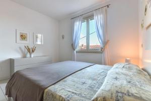 Un dormitorio con una cama grande y una ventana en Mimì, en Capoliveri
